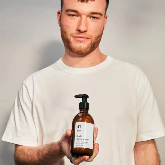 47 Skin Anti Blemish Scar Repair Body Moisturiser - male model holding bottle in his hand